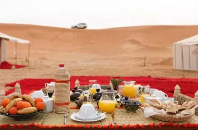 Breakfast laid out on rugs on the sand at a desert camp, Morocco