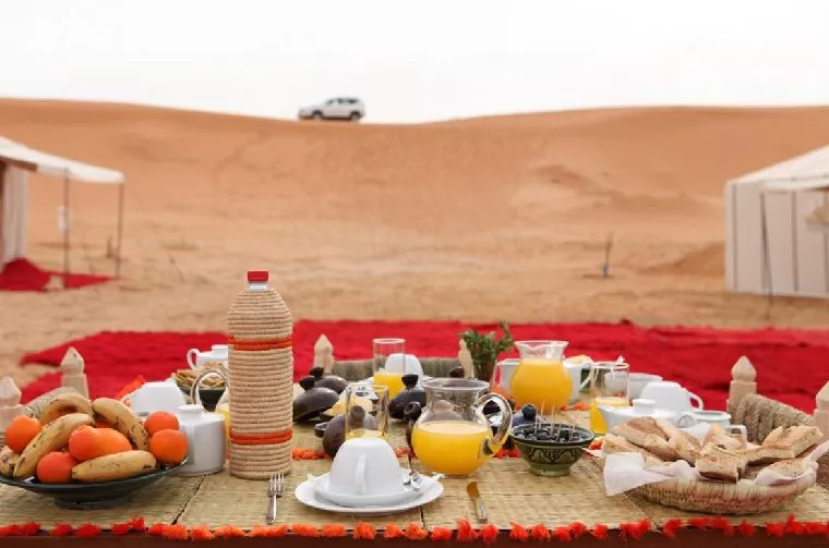 Breakfast laid out on rugs on the sand at a desert camp, Morocco