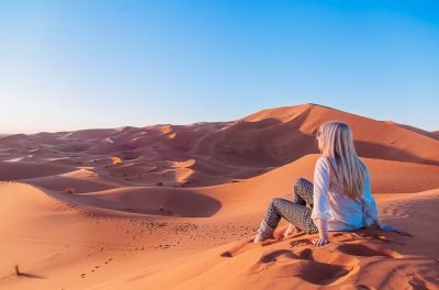 Traveller sitting on the Erg Chebbi dunes at Merzouga, Morocco