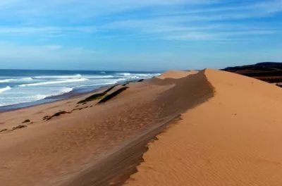 Sand dunes meeting the Atlantic Ocean on the coast south of Agadir, Morocco