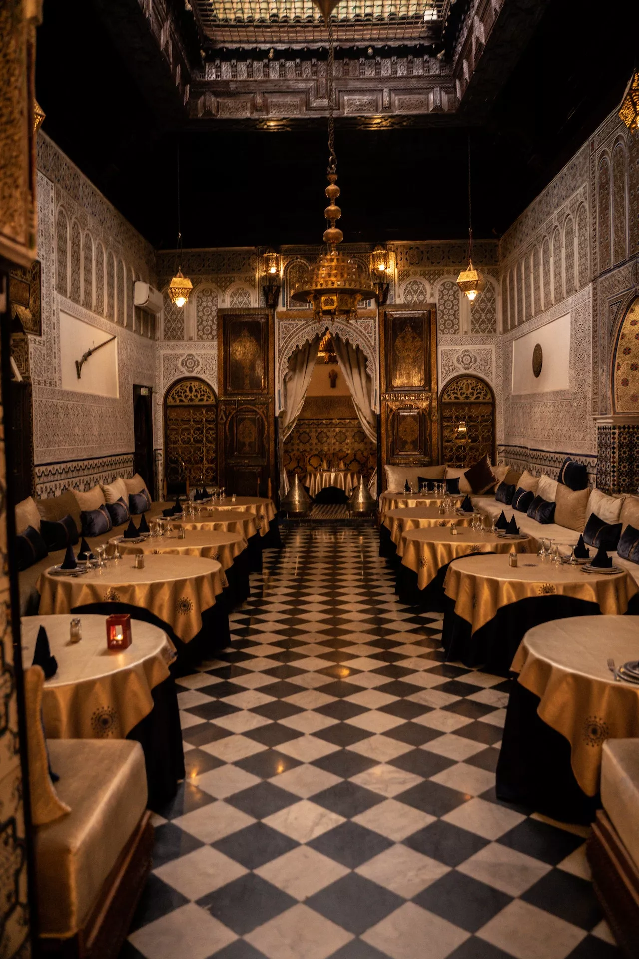 Chequered floor and carved walls of a restaurant in a Fes riad