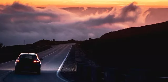 Car driving a mountain road at dusk in Morocco