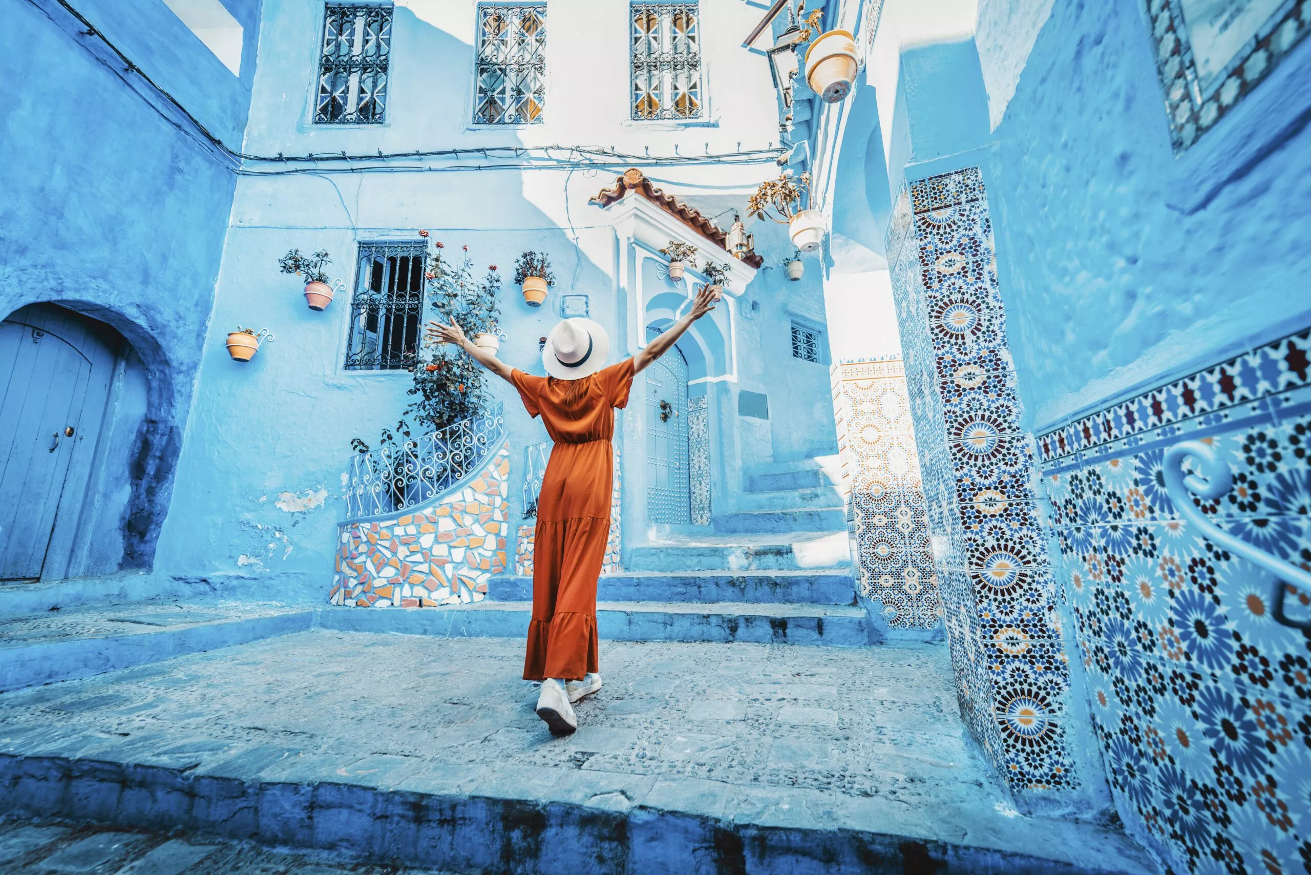 Traveller in a red dress in a blue lane of the Chefchaouen medina