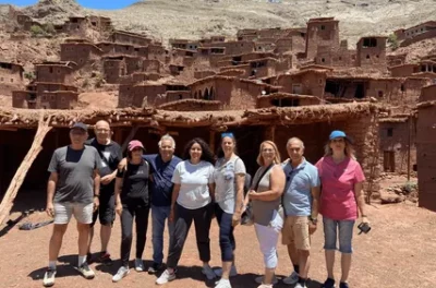 Tour group posing in front of the Ait Ben Haddou kasbah, Morocco
