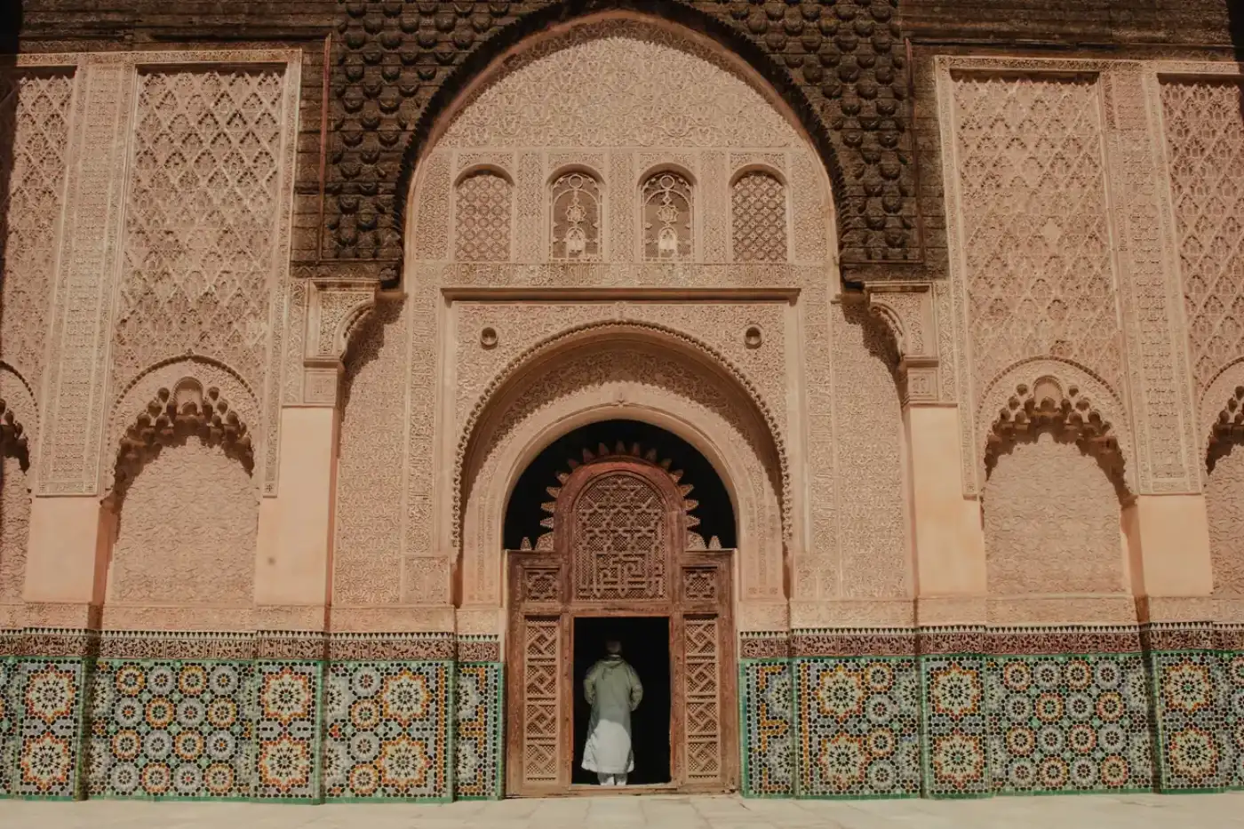 Ornately carved archway and zellige tilework in the Marrakech medina, Morocco